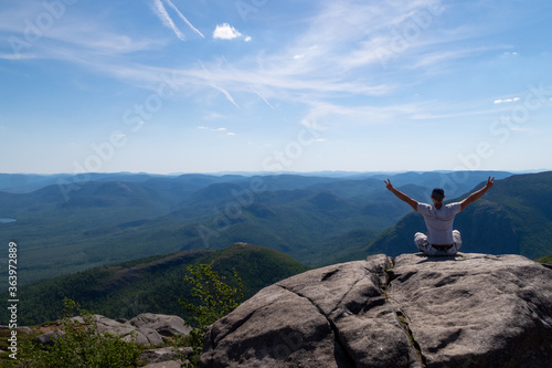 Young man admiring the landscape at the top of the "mont du lac des cygnes" (swan lake mountain) in Charlevoix, Quebec