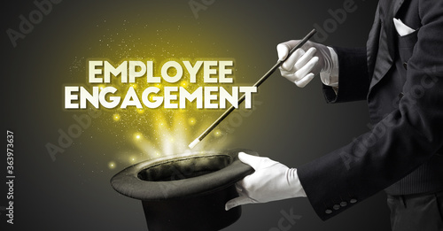 Illusionist is showing magic trick with EMPLOYEE ENGAGEMENT inscription, new business model concept