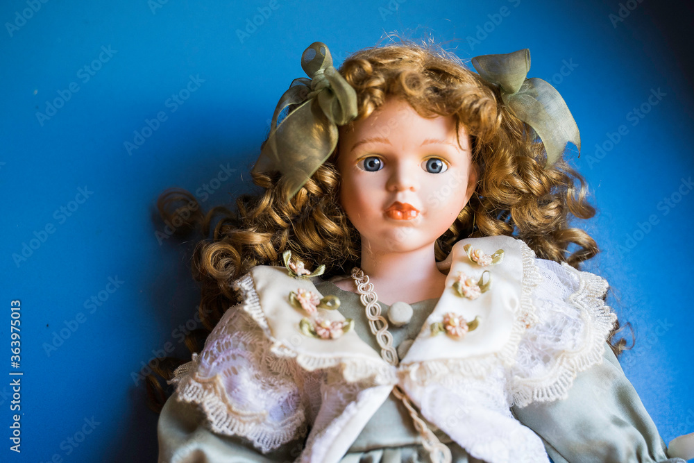 Fototapeta premium Porcelain doll face on blue background