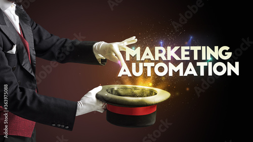 Illusionist is showing magic trick with MARKETING AUTOMATION inscription, new business model concept