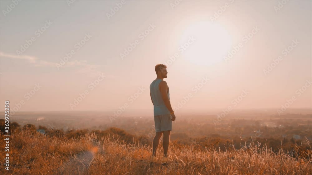The handsome sportsman runs on the top of the hill The handsome sportsman runs on the top of the hill