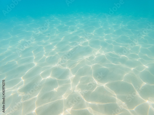 Underwater still of the water waves reflection on white sand in the Mediterranean Sea