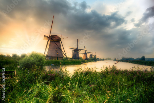 Beautiful Dutch windmills and landscape under dramatic sunset sky 
