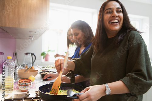 Happy Indian women cooking food in kitchen