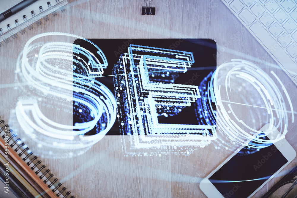 Double exposure of SEO hologram drawing over desktop. Top view. Search optimization concept. Double exposure of SEO hologram drawing over desktop. Top view. Search optimization concept.