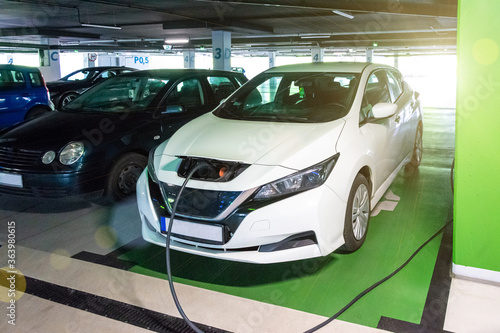 Electric transports. Electric car charge battery on eco energy charger station. Hybrid vehicle - green technology of future. Eco-friendly sustainable energy concept.