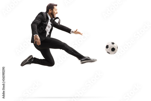 Man in a suit jumping and kicking a soccer ball © Ljupco Smokovski