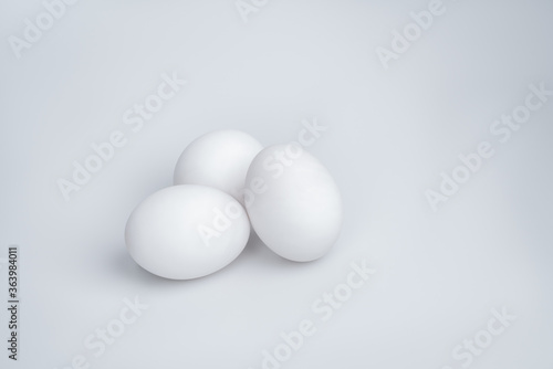 Three white eggs on a white background