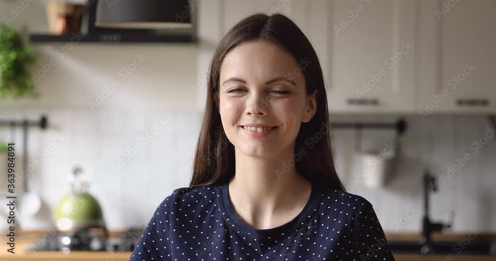 Head shot portrait attractive woman standing in domestic cozy home kitchen smiling looking at camera. Telecommuting distance working person, HR workforce, millennial generation representative concept Head shot portrait attractive woman standing in domestic cozy home kitchen smiling looking at camera. Telecommuting distance working person, HR workforce, millennial generation representative concept