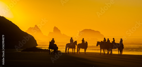 Horseback riders on the beach at Bandon, on the southern Oregon coast,  at sunset