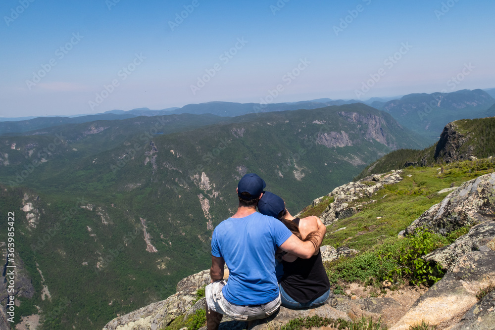 Back view of a young couple sitting at the top of the 