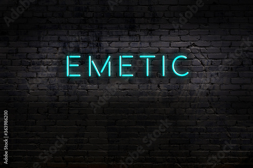 Night view of neon sign on brick wall with inscription emetic photo