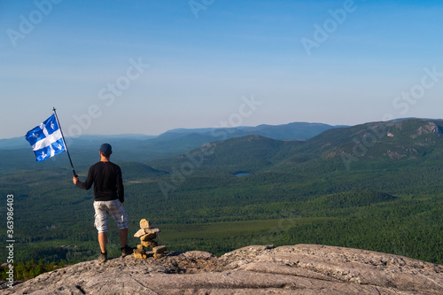 Man with a fleurdelisé flag from Quebec on the top of 