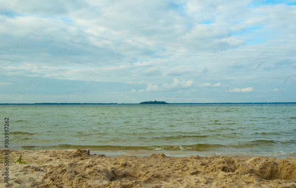 Summer landscape of the big lake Svityaz with an island and the blue sky with single clouds Summer landscape of the big lake Svityaz with an island and the blue sky with single clouds