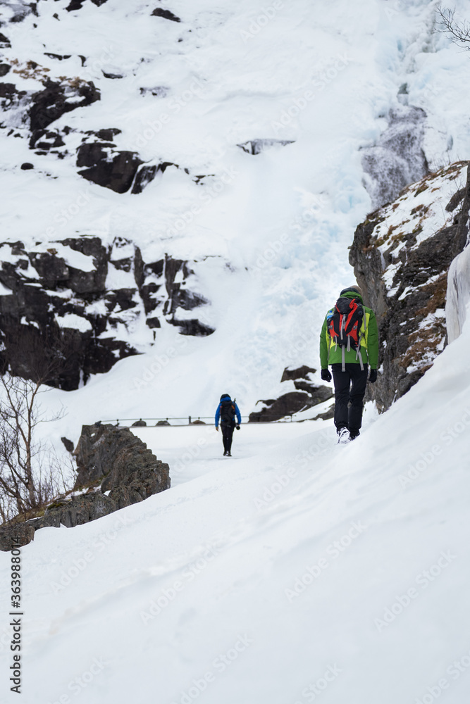 Hikers in winter on Trollstigen is Norway’s most visited tourist road 