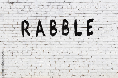 Obraz na plátne White wall with black paint inscription rabble on it