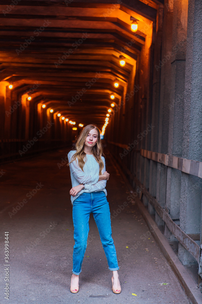 Young girl standing in a tunnel with lights