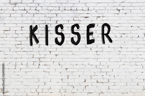 Inscription kisser painted on white brick wall photo