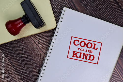 Red Handle Rubber Stamper and Cool to be Kind text isolated on the table.
