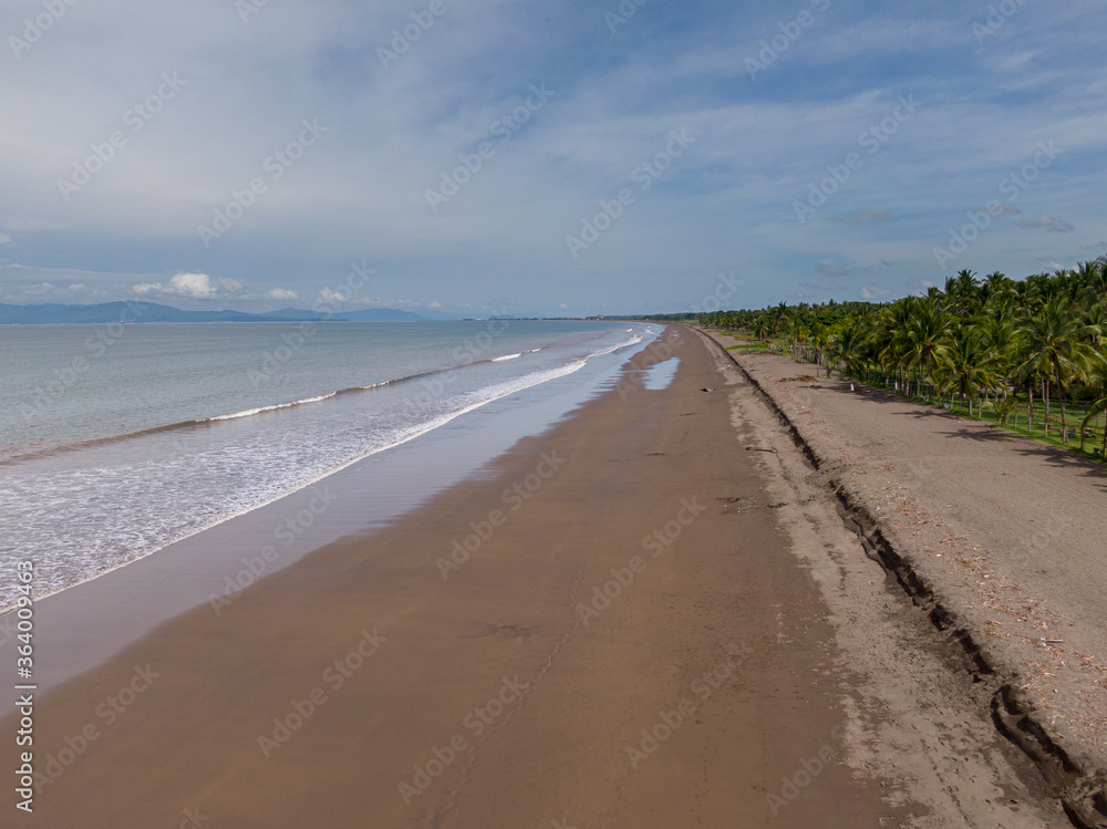 Beautiful aerial view of a empty beach due to the quarantine for Covid19, with a police car in Costa Rica 
