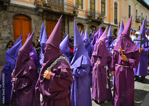 The catholic procession of the penitent cucuruchos ith purple clothing in Quito during Easter on Holy Friday, Ecuador. photo