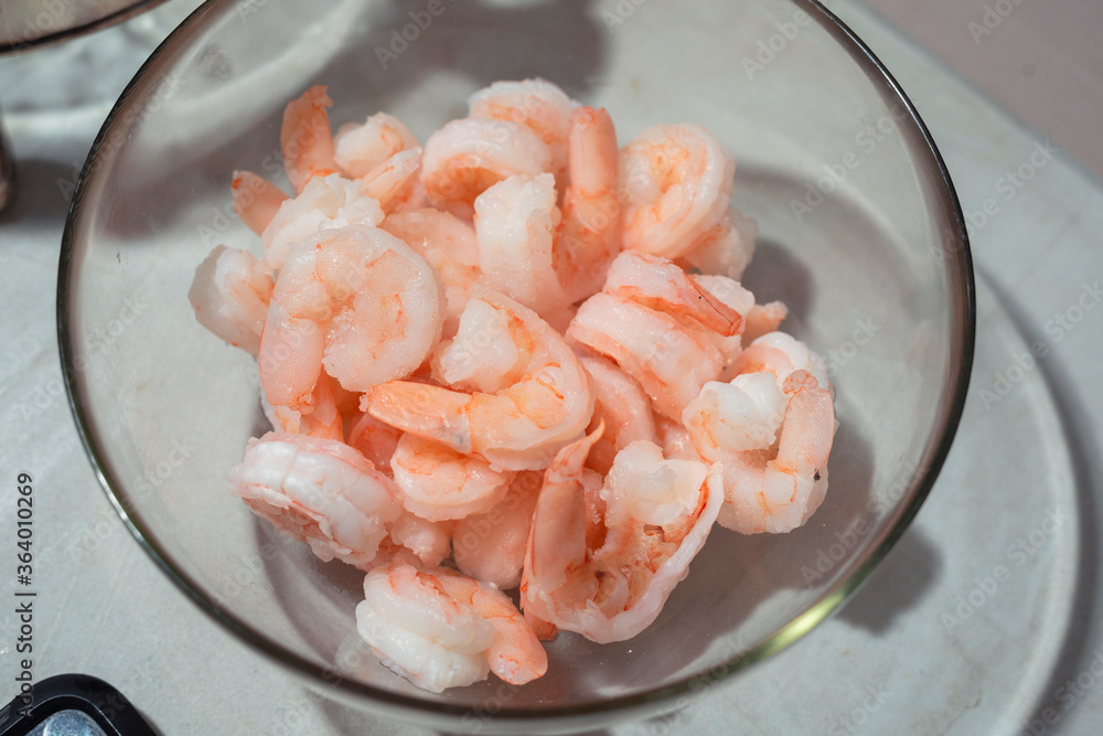 Fresh raw shrimp in a bowl on a white table - skinless shrimp Fresh raw shrimp in a bowl on a white table - skinless shrimp