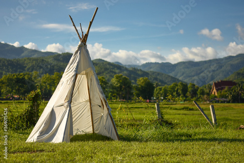 White tent in the sunset overlooking mountains and nature background. © Jakkapong