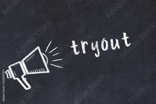 Chalk loudspeaker and inscription tryout on black chalkboard