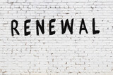 Inscription renewal painted on white brick wall