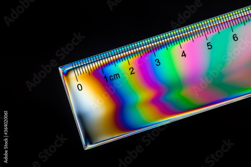 close up of a ruler in polarized light on black background.