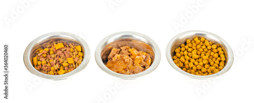 Metal bowls with different pet foods. Photo