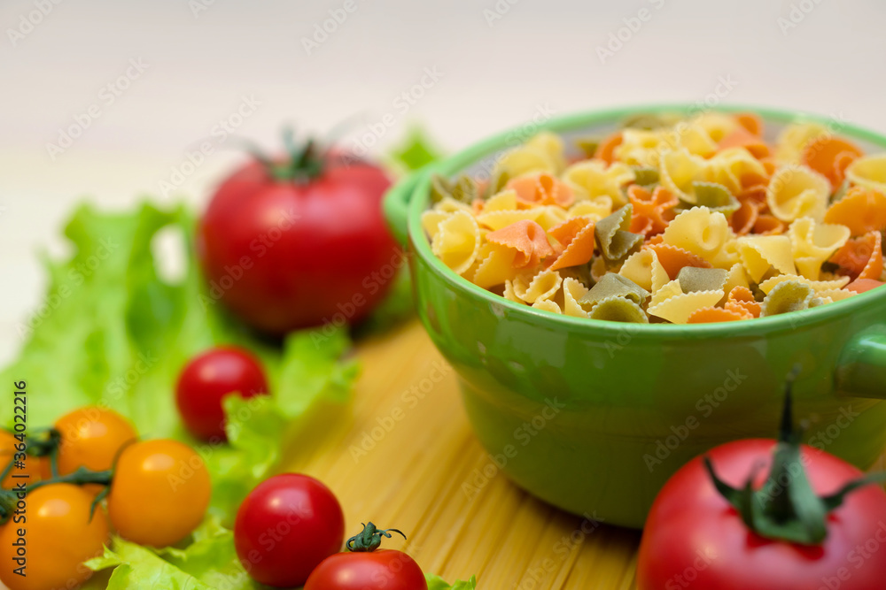 Pasta with vegetables in a plate. Ingredients for cooking Italian Pasta. Tomatoes, cherry greens. Background from spaghetti. Pasta with vegetables in a plate. Ingredients for cooking Italian Pasta. Tomatoes, cherry greens. Background from spaghetti.