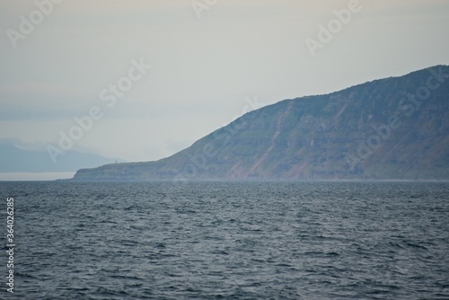 Steep shores of the Kuril Islands. Islands in the sea. Fall. © German