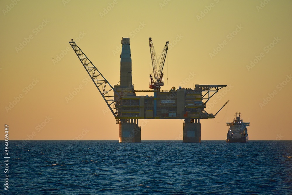 Oil platform at sea. Extraction of minerals on the shelf. A huge platform rises above the water. Hydrocarbon energy. 
