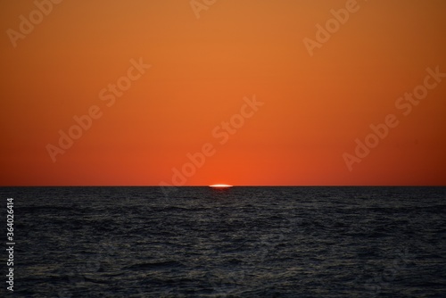 A cold orange sun sets on the North Sea. Fall. Cold evening. Photo from the side of the ship. © German