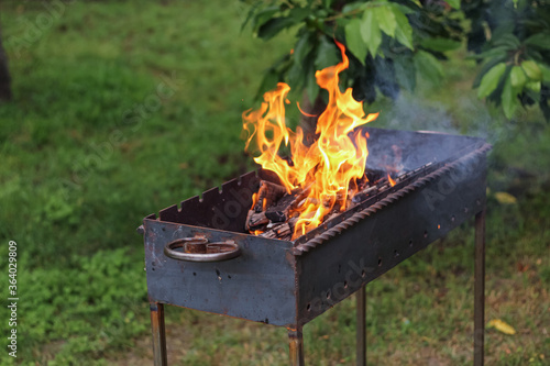 Burning firewood in a barbecue for cooking barbecue outdoor