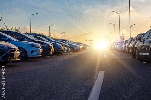 A roadside parking lot full of cars at sunset