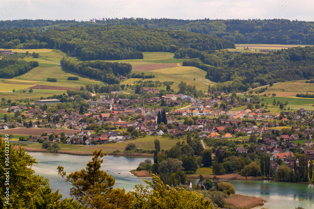 Aerial view of the scenic Swiss town of Stein am Rhein near river Rhine. Image features traditional houses, St George's Abbey, farm lands, meadows and a forest.