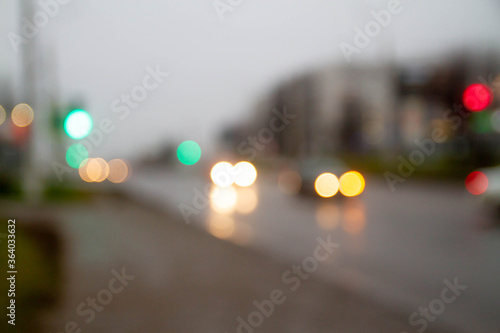 Traffic traffic in the town. Green traffic light. Cars go on the road. Blurred image. Wet road after rain.