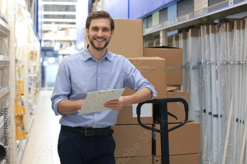 Foto portrait of a smiling young warehouse worker working in a cash and carry wholesale store