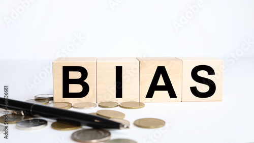 On a white background wooden cubes. Business concept. TEXT on Bias .Bias wooden blocks - word from wooden blocks with letters, personal opinions prejudice bias concept, random letters around photo