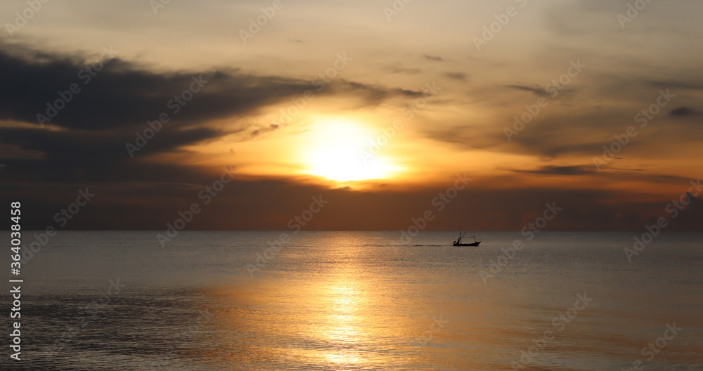 silhouette boat in the sea at sunset on the beach