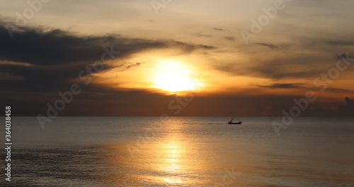 silhouette boat in the sea at sunset on the beach © Touchi
