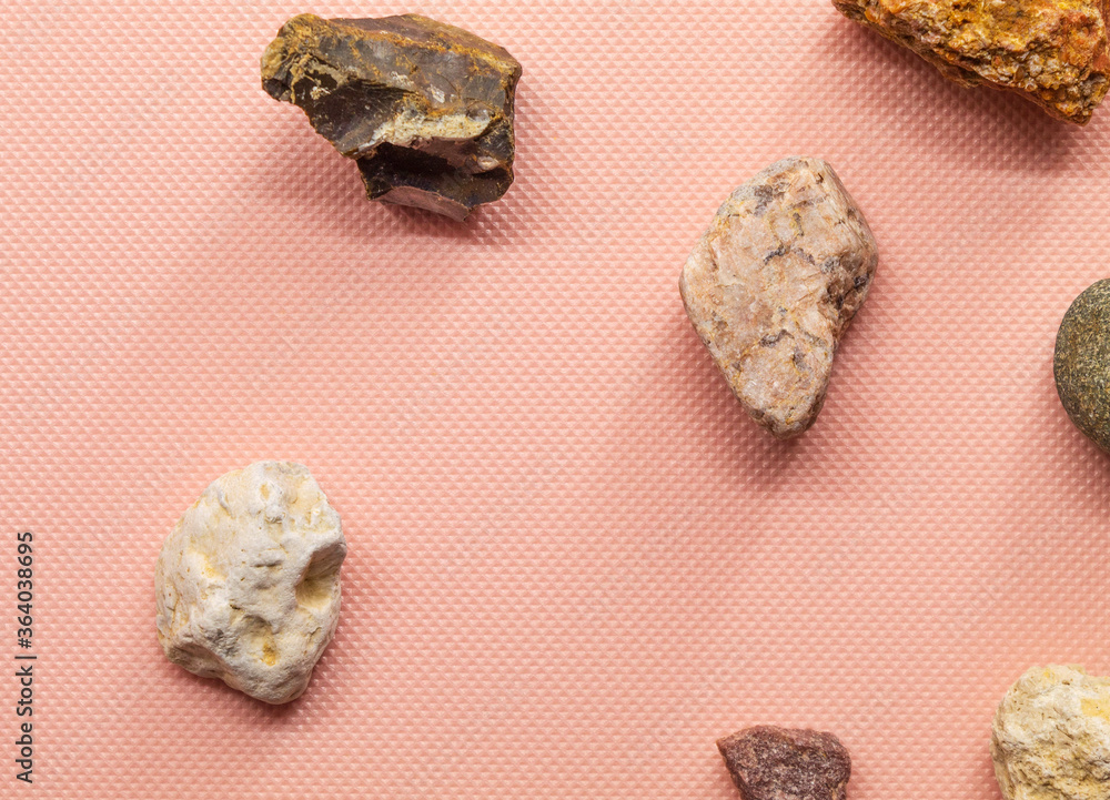 Seven stones lie separately from each other on a pink background Seven stones lie separately from each other on a pink background