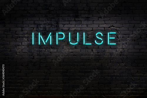 Neon sign. Word impulse against brick wall. Night view