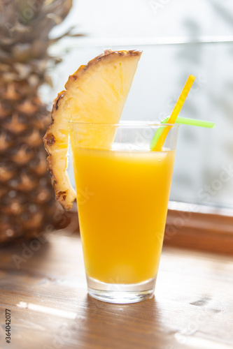 sweet pineapple juice in a glass with pineapple in the background