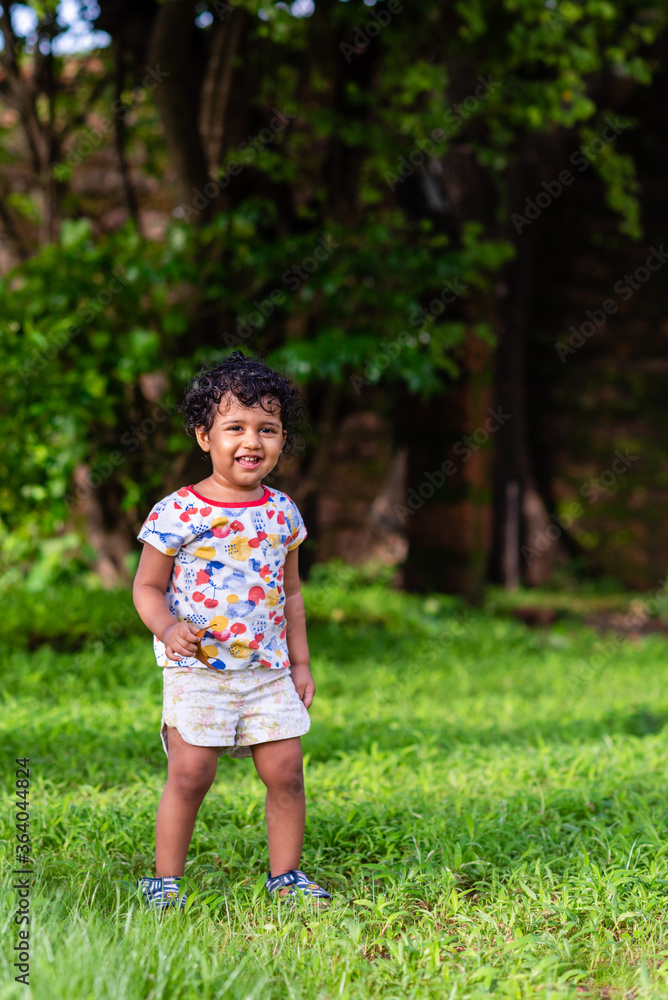 Playful Pretty Indian girl child/infant playing outdoors with nice environmental background Playful Pretty Indian girl child/infant playing outdoors with nice environmental background