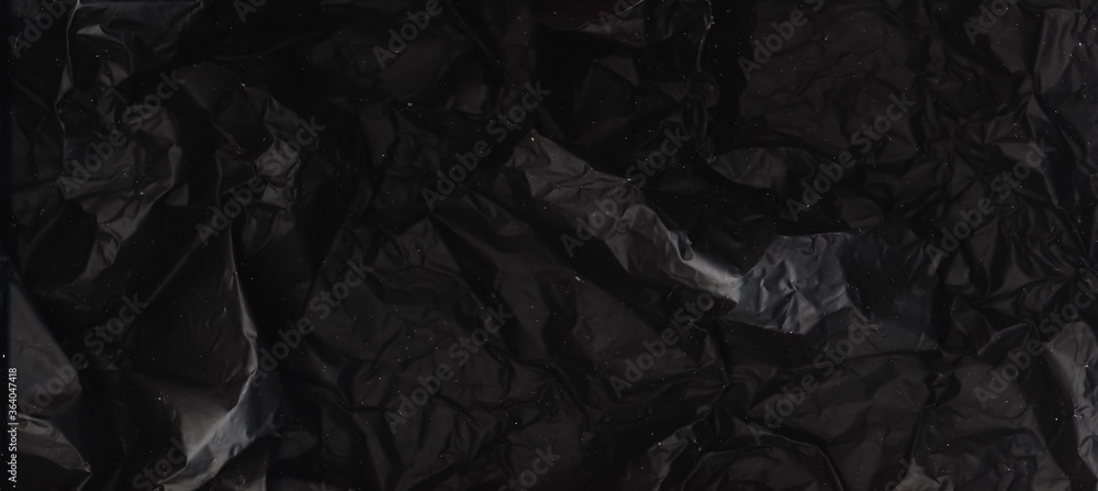 Black foil background. Crumpled texture. Crushed burnt paper structure. Black foil background. Crumpled texture. Crushed burnt paper structure.