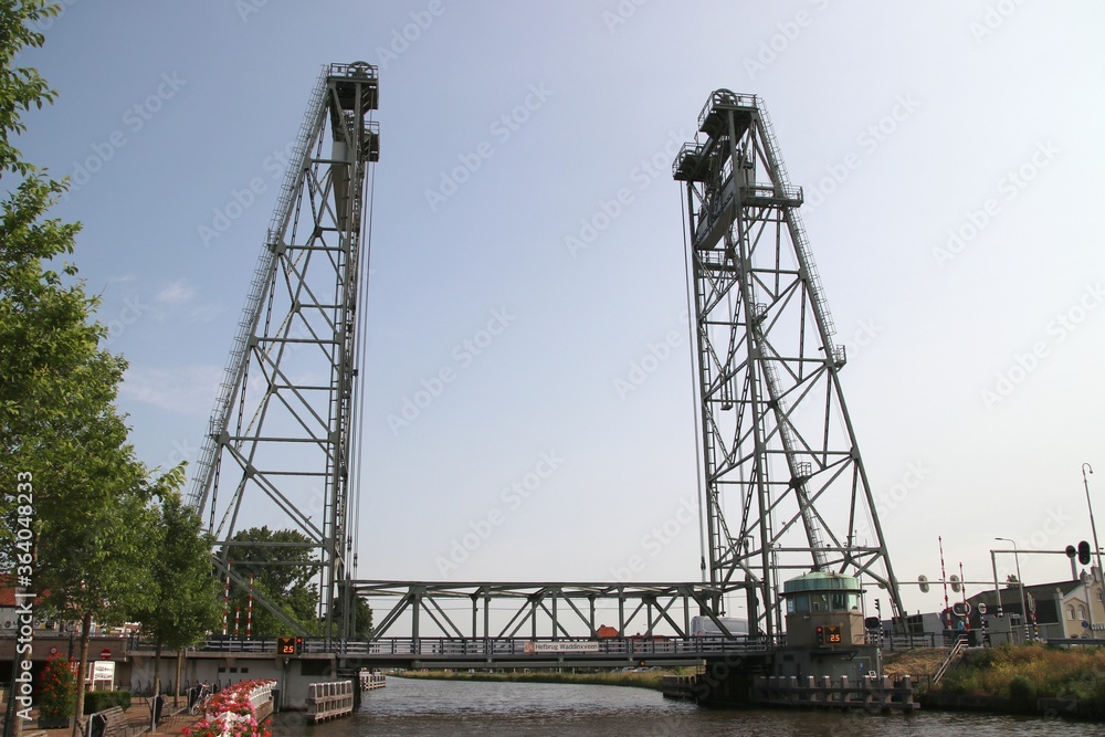 Water of the Gouwe Canal with in the background the green steel vertical lift bridge of Waddinxveen in the Netherlands.