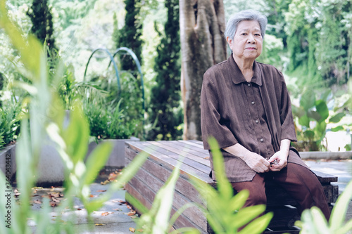elder woman resting in garden. elderly female relaxing outdoors. senior leisure lifestyle